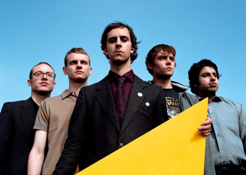 Band Maximo Park with blue sky background, singer holding a yellow objectx